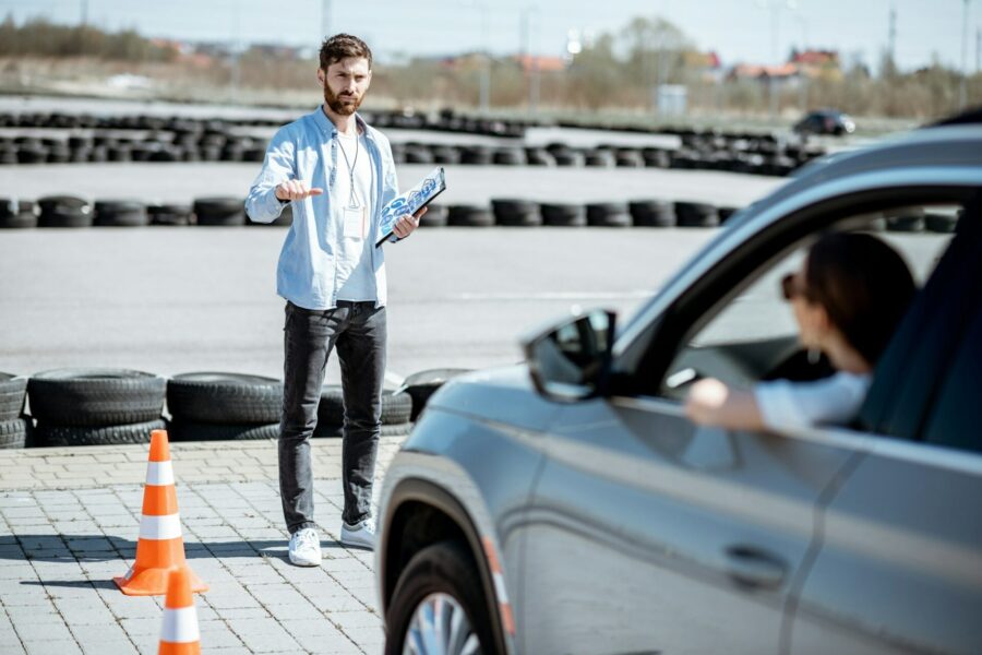 Instructor teaching to drive a car on the training ground